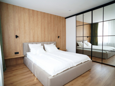 Zabudowa sypialni : drzwi z lustrami i drewnopodobna ściana